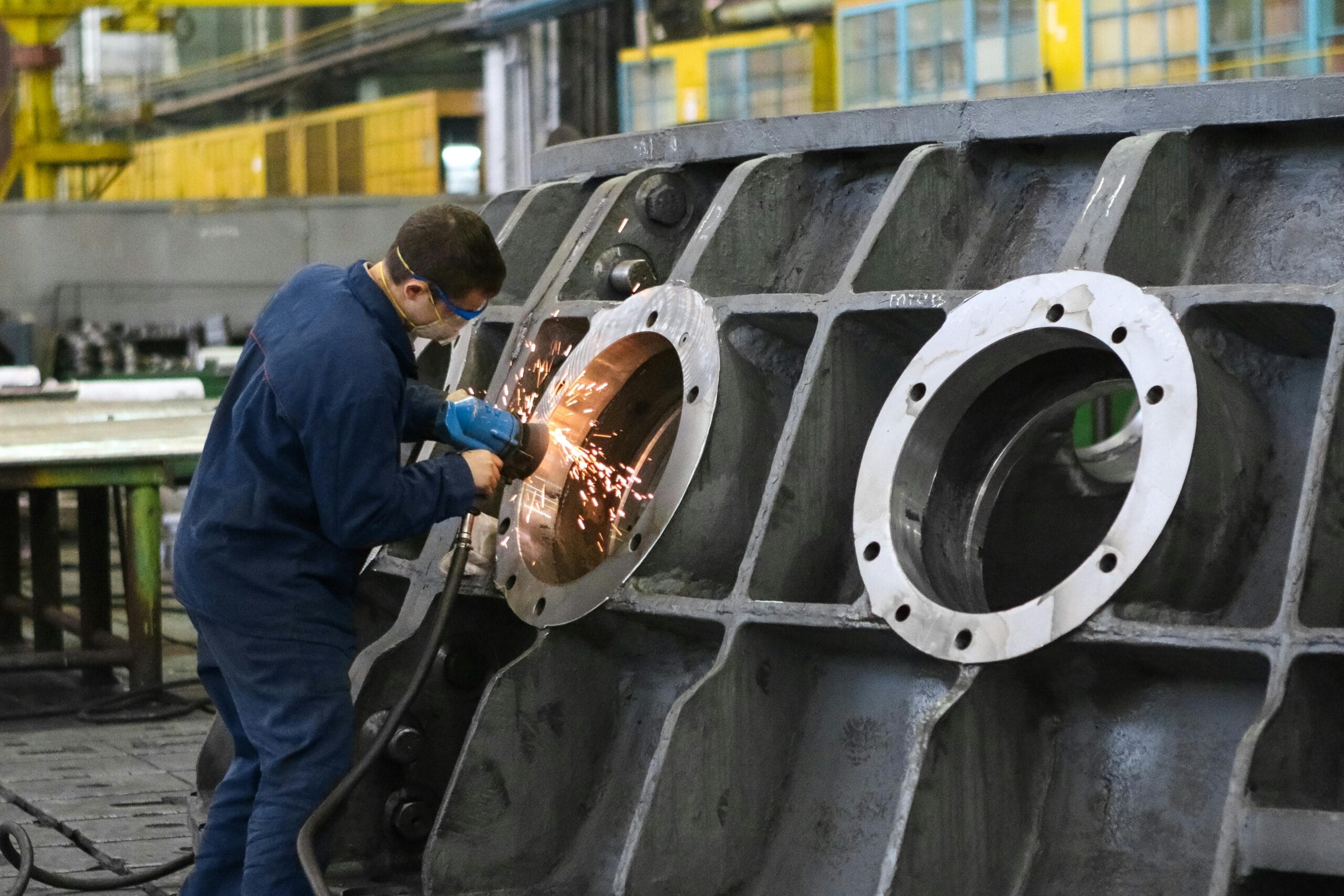 Industrial worker welding equipment at a manufacturing facility, showcasing property tax solutions for heavy industry.