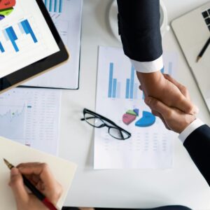 Handshake over industrial property assessment documents for negotiation and appeal services.